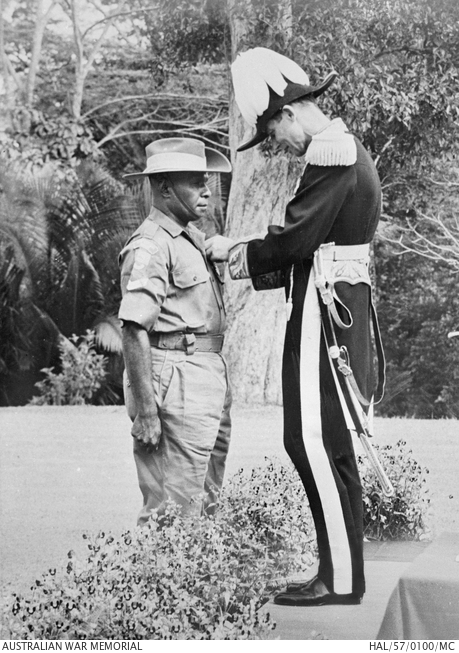 A Torres Strait Islander, Corporal Charles Mene, receiving the Military Medal from the British High Commissioner to the Federation of Malay States.