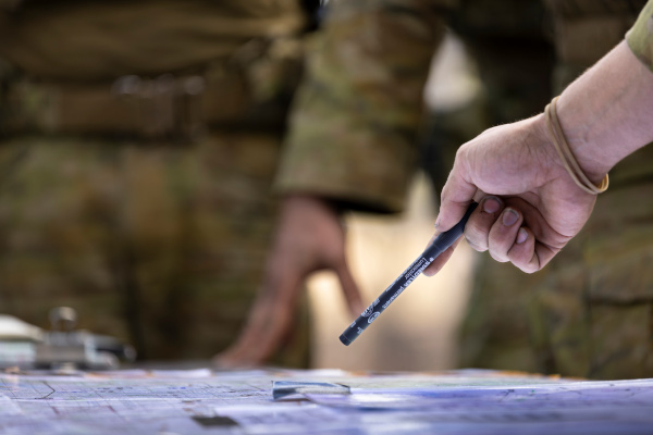 A soldier pointing at documents.