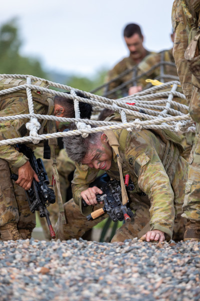 Soldiers crawling under a net