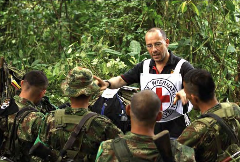 An ICRC employee speaks to members of the National Liberation Army (ELN) armed group