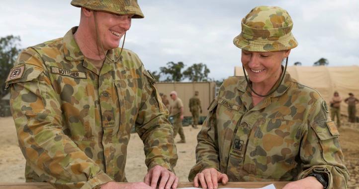 Two soldiers looking at plans.