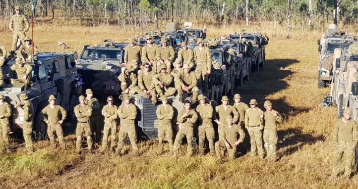 Soldiers standing near trucks.