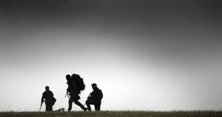 Soldiers walking on a hill.