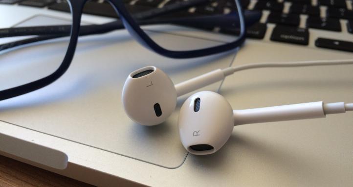 Headphones and glasses on a laptop.