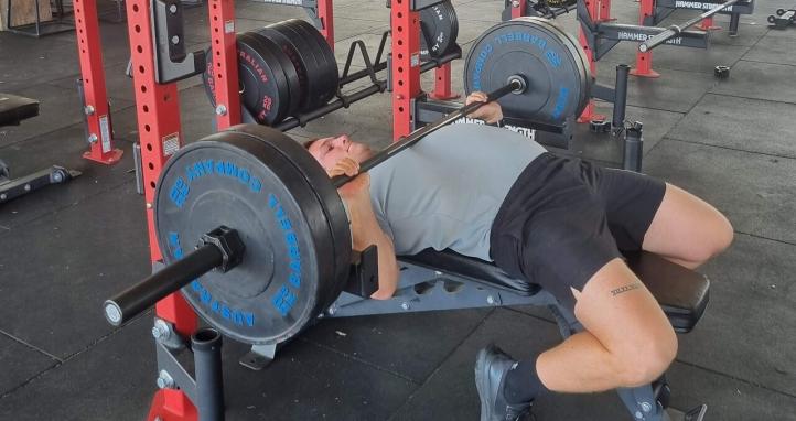 A man using a bench press.