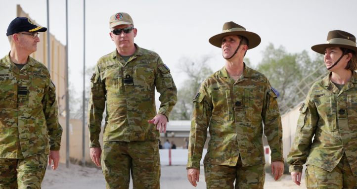 Four soldiers walking on base.