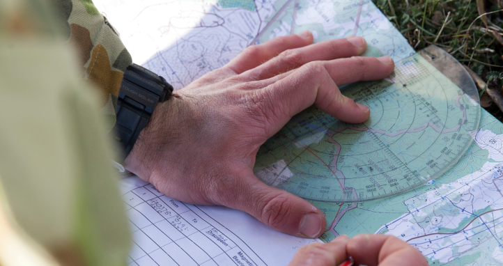 A staff cadet plots their coordinates, during a navigation training exercise at the Majura training area.