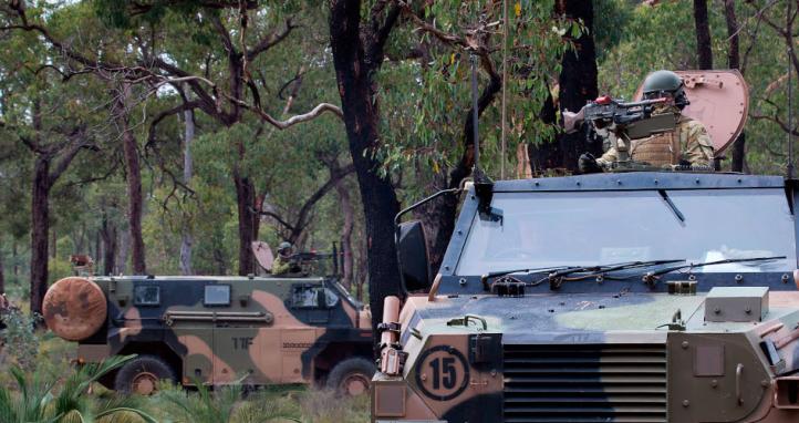Bushmasters move into defensive positions during a contact drill as part of Exercise Damour at the Bindoon Military Training Area, Western Australia.