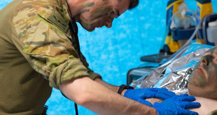 An army medical worker attends a patient.