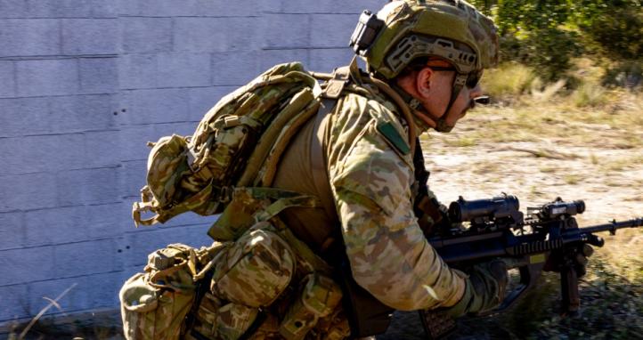 An Australian Army soldier runs to take up a firing position during an assault on an 'enemy' defensive position during an exercise.