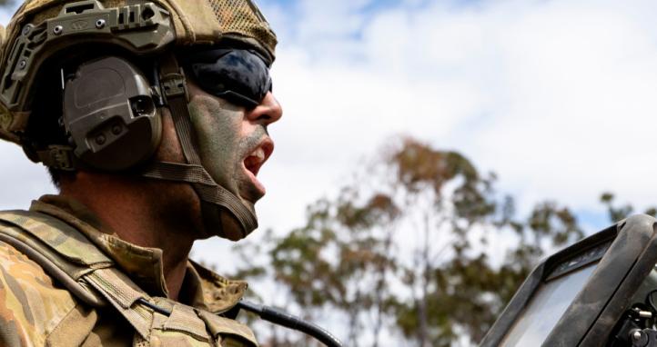 An Australian Army soldier delivers orders during a live-fire fire mission.