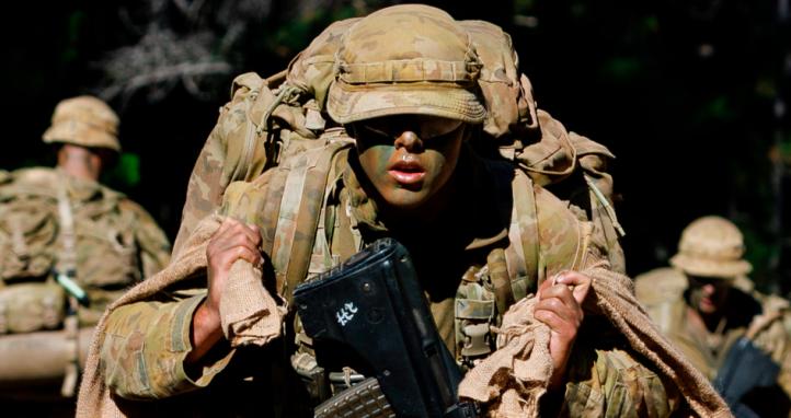 An Australian Army Staff Cadet carrying sandbags.