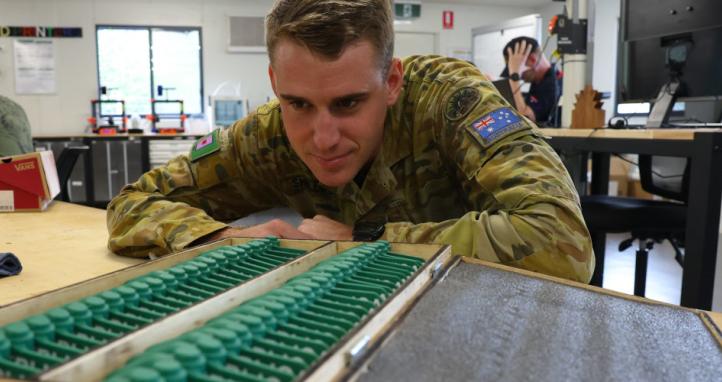 An Australian Army combat engineer with 3D-printed replica PFM-1 butterfly mines.
