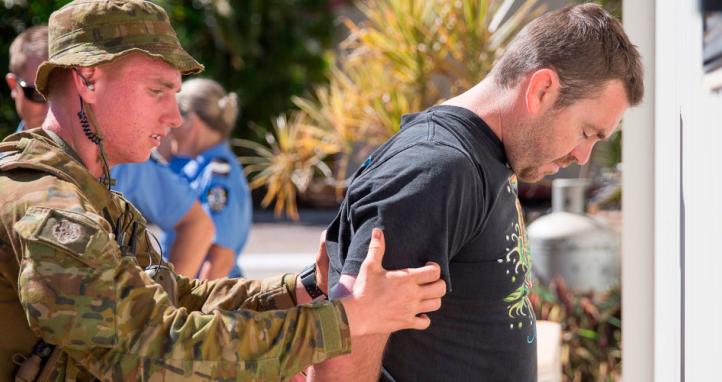 An Australian Army soldier searches a 'suspect' during a mock cordon and search operation.