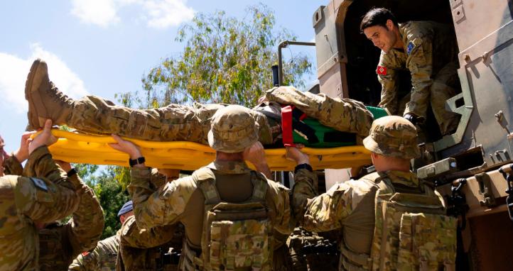 Australian Army soldiers extract a casualty role-player from a vehicle.