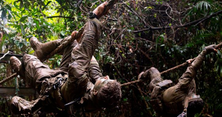 Australian Army soldiers traverse across a rope obstacle.