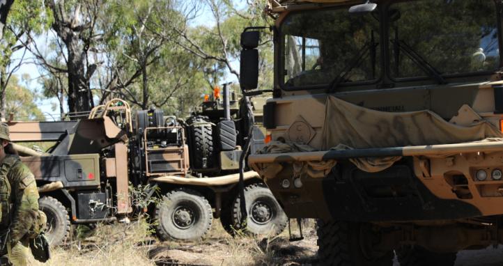 An Australian Army soldier leads an Australian Army HX77 to position.