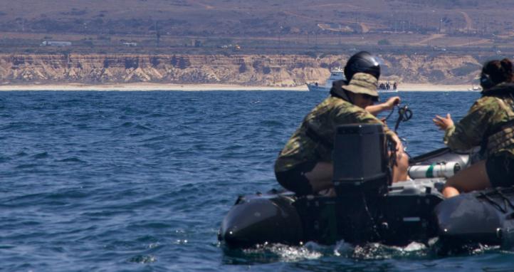 Multinational training participants launch a REMUS 100 autonomous underwater vehicle (AUV).