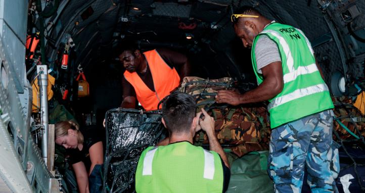 Royal Australian Air Force personnel work with the Papua New Guinea Defence Force to load a C-27J Spartan aircraft.