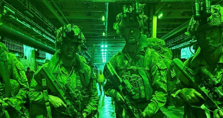 Soldiers illuminated by night vision.