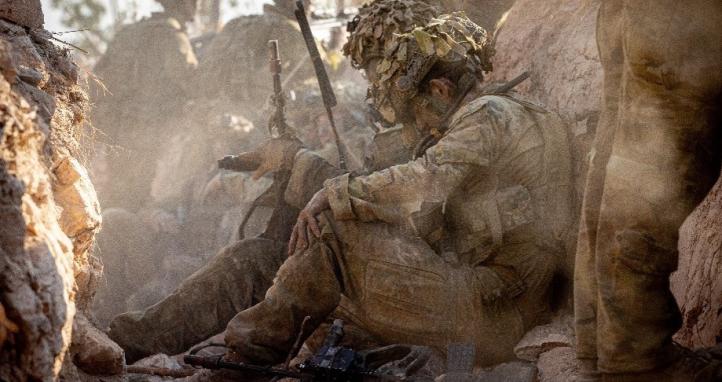Soldiers sitting amongst the dust.