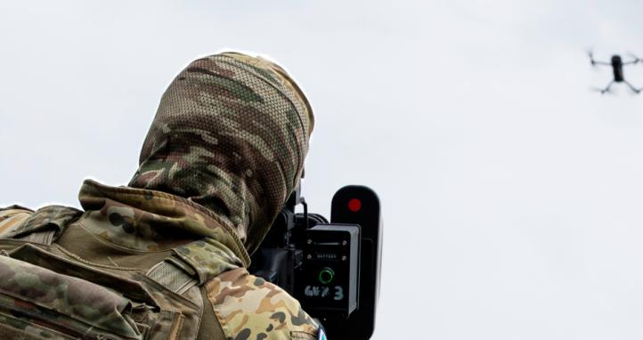 An Australian Army soldier takes aim to jam a drone mid-flight.