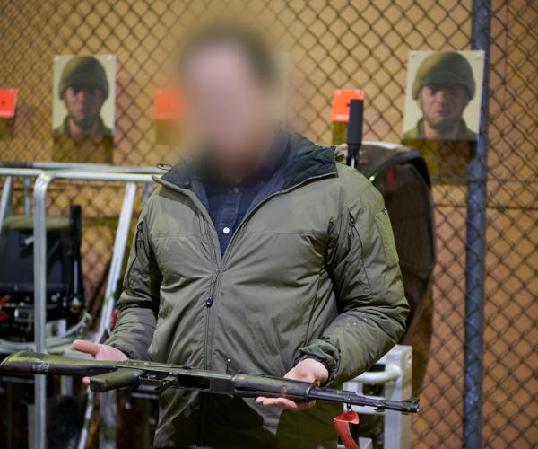 A man holding a rifle in a shooting range.