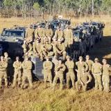 Soldiers standing near trucks.