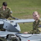 Soldiers standing near drones.