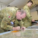 Soldiers writing on a map.