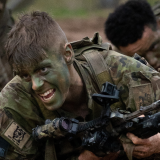Soldier doing a leopard crawl across the sand pit.