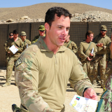 Joel McMahon receives an award from a soldier in Afghanistan.