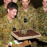 A soldier receives a birthday cake.