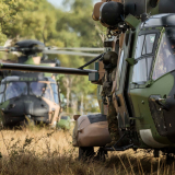 Soldiers hopping out of a helicopter.