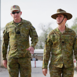 Four soldiers walking on base.