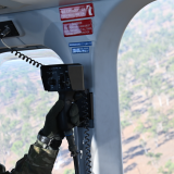 Aircrewman scans the ground from a AW139 Leonardo helicopter.