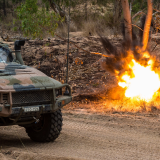 A simulated munition explodes next to a Light Hawkei.