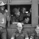 Troops of the 2/7th Infantry Battalion in the carriages and on the station platform.