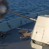 The Mark 45 Mod 6 5-inch gun of HMAS Hobart engages a towed surface target during weapon trials off the east coast of Australia.