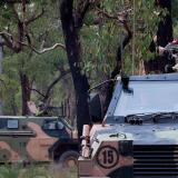 Bushmasters move into defensive positions during a contact drill as part of Exercise Damour at the Bindoon Military Training Area, Western Australia.