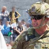 An Australian solider assists the Department of Foreign Affairs and Trade with locating Afghan Australian visa holders attempting to enter the congested Abbey Gate at Hamid Karzai International Airport.