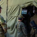 Australian Army Staff Cadets line up outside a mess tent.