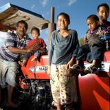 A Tongan family posing on a tractor.