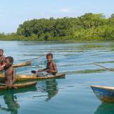 Solomon Islanders fishing in dug out canoes.