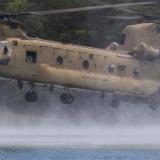 Personnel from the Australian Army, United States Army and Armed Forces of the Philippines swim to shore after helocasting from a United States Army CH-47 Chinook.