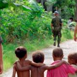Members of the United Nations Transitional Administration in East Timor (UNTAET) Portuguese contingent are accompanied by a group of local children as they conduct a security patrol in the Becora district of Dili.