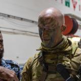 An Australian Army soldier discusses the proceedings of a scheduled air assault with members of the Sri Lanka Marine Corps onboard HMAS Canberra during RIMPAC (RIMPAC) 2022.