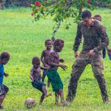 Australian Army Jonathan Church Good Soldiering Award recipients play a game of soccer with the children of Illi Village after walking the coastal track from Nongia Village at Alder Bay in East New Britain, PNG during a historical battle tour.