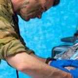 An army medical worker attends a patient.