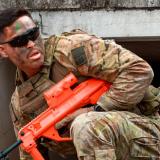 An Australian Army Gunner crawls through a tunnel a part of the bayonet assault course.